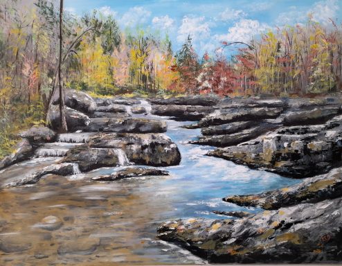 CASACDE DE MONTAGNE - Rivière jonchée de rochers et d'arbres aux feuillages d'automne. Ciel bleu clair.