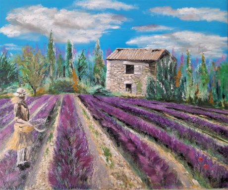 Femme marchant dans un champ de lavande avec une maison en pierre en arrière-plan.